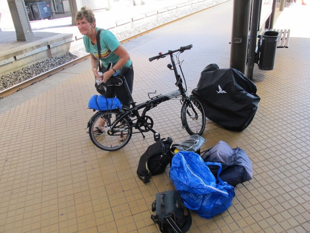 Bev preparing to fold her bike. My bike is folded and in its protective bag leaning against the stanchion. 